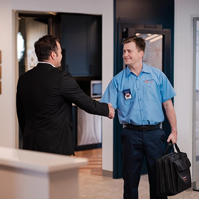 Mr. Appliance service professional shaking hands with a customer in his home.